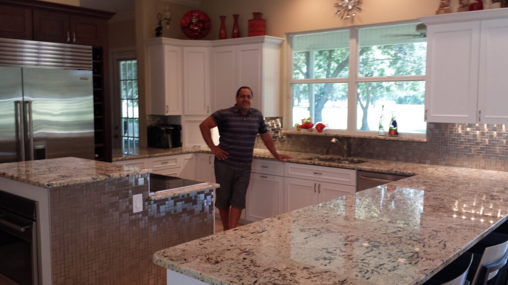 Founder standing in a modern Tampa kitchen showcasing high-quality kitchen cabinets and appliances.